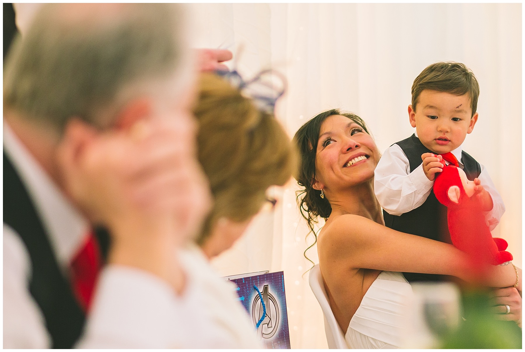 Bride looks on and smiles during speeches