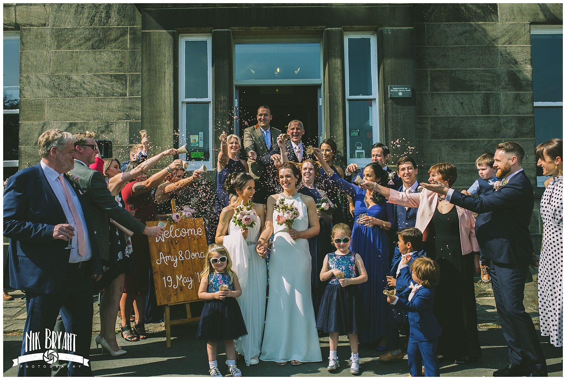 two brides showered in confetti by friends and family