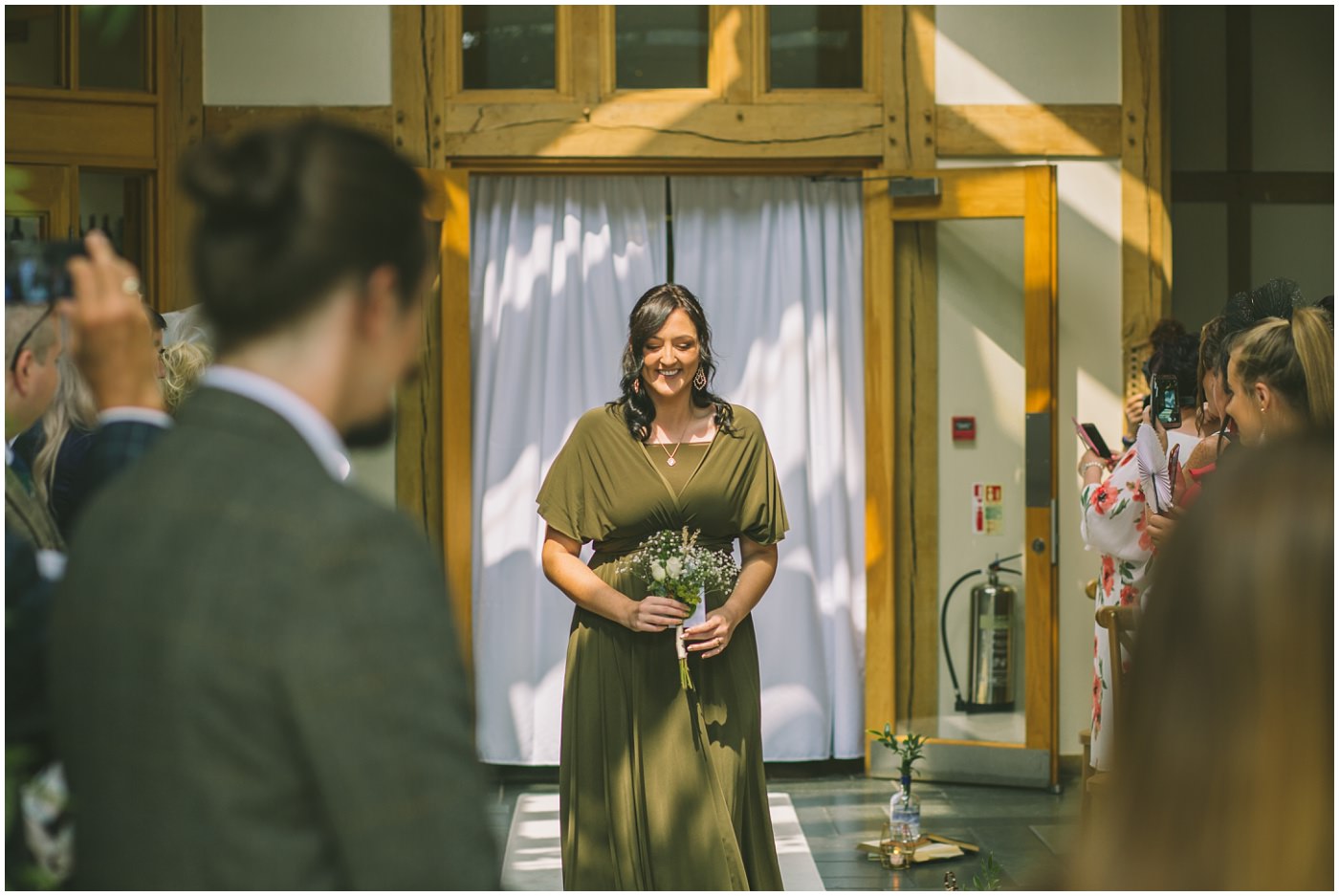 bridesmaid carrying home made bouquet walks the isle
