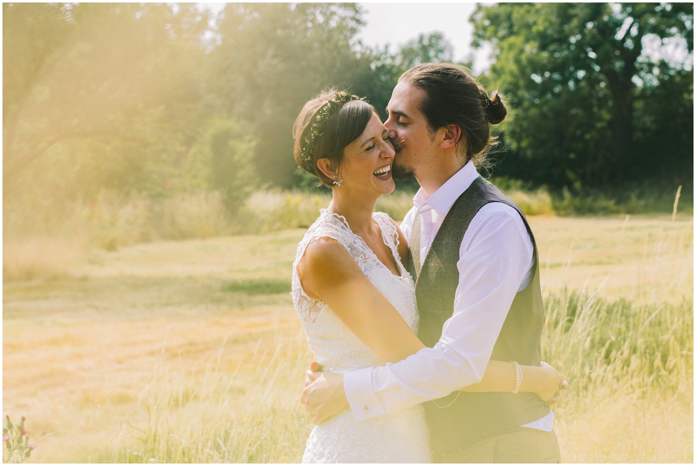 groom kissing his bride on the cheek during bridal portraits