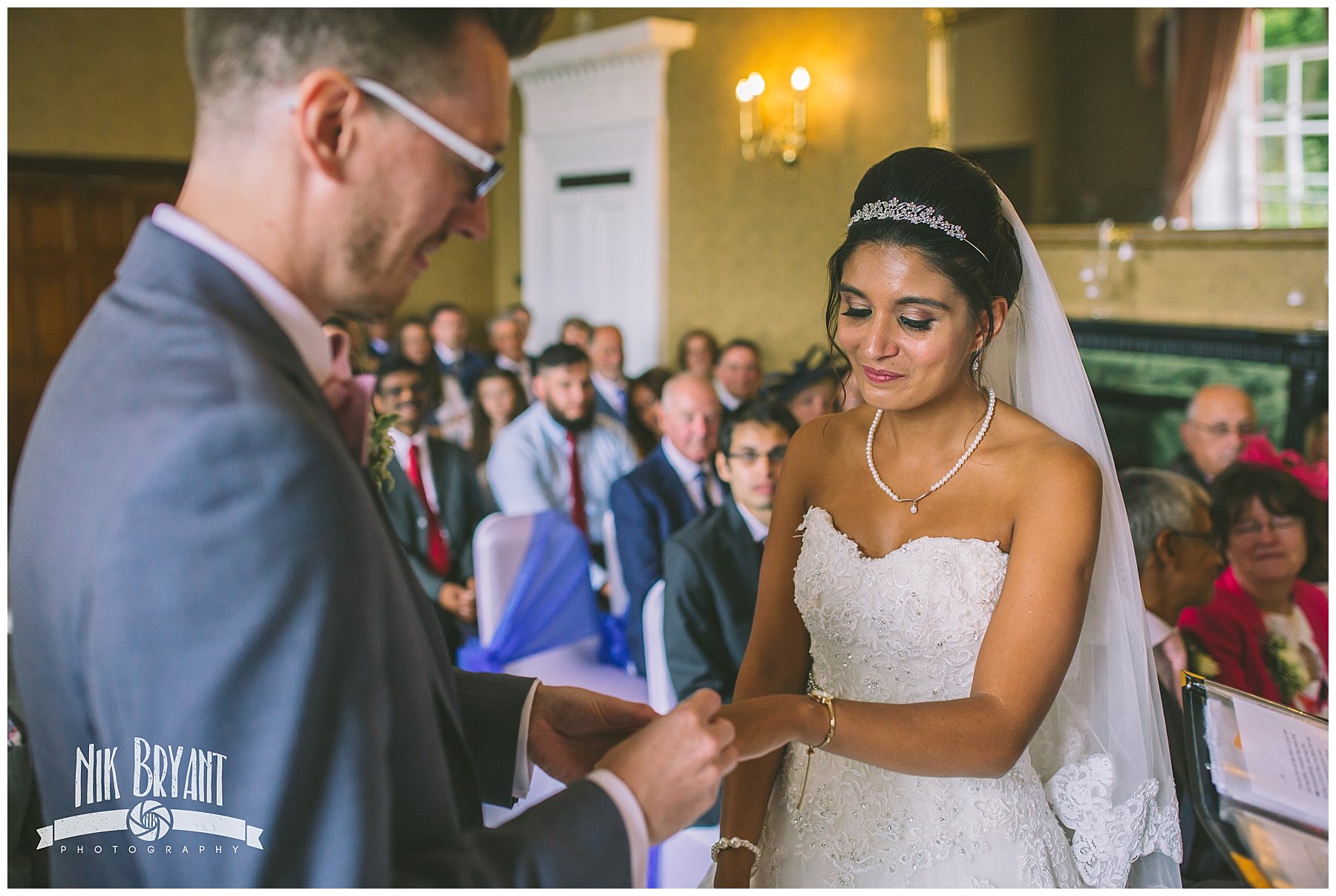 Bride and groom exchange rings during wedding ceremony
