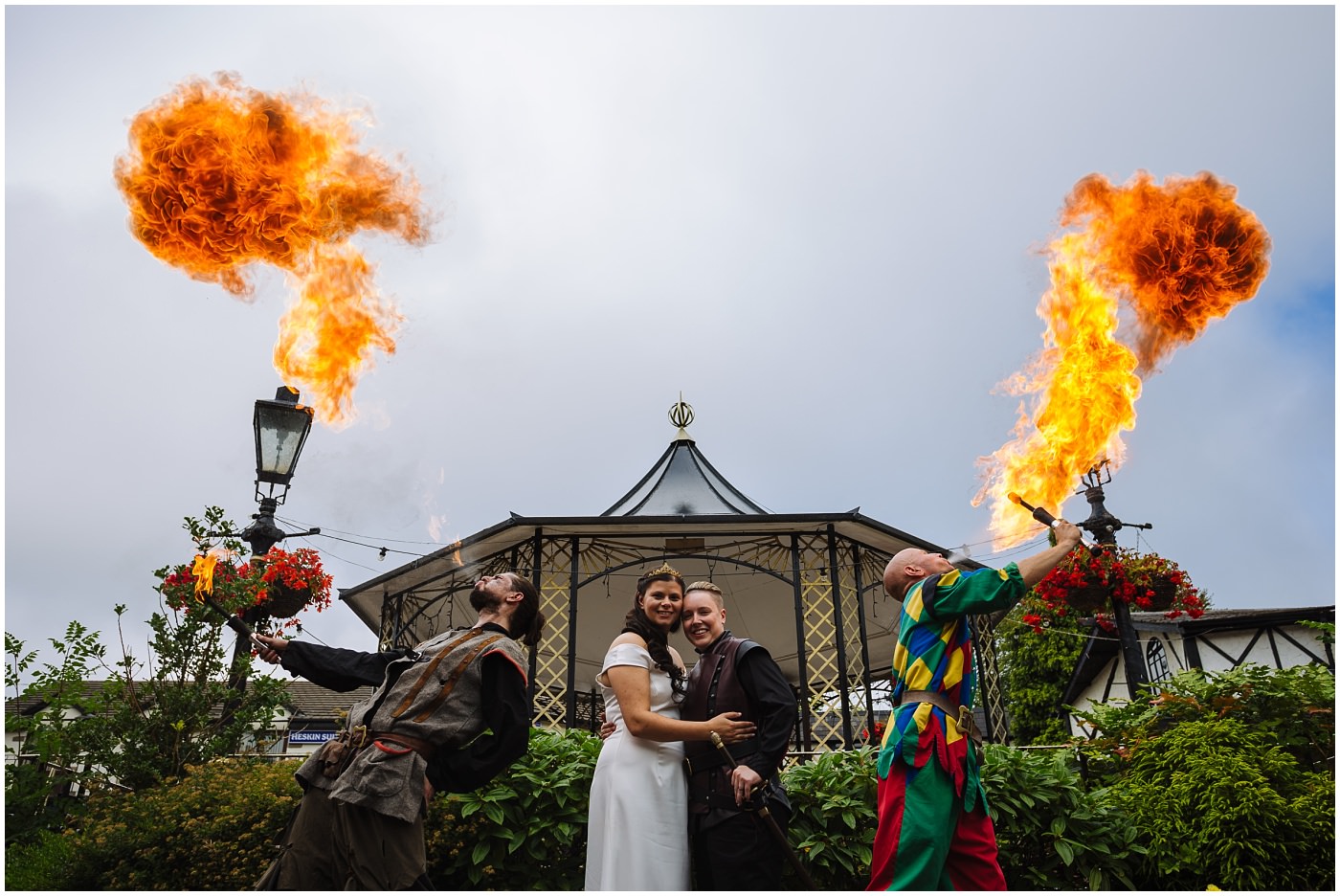 Newly wed couple stand between two fire breathers