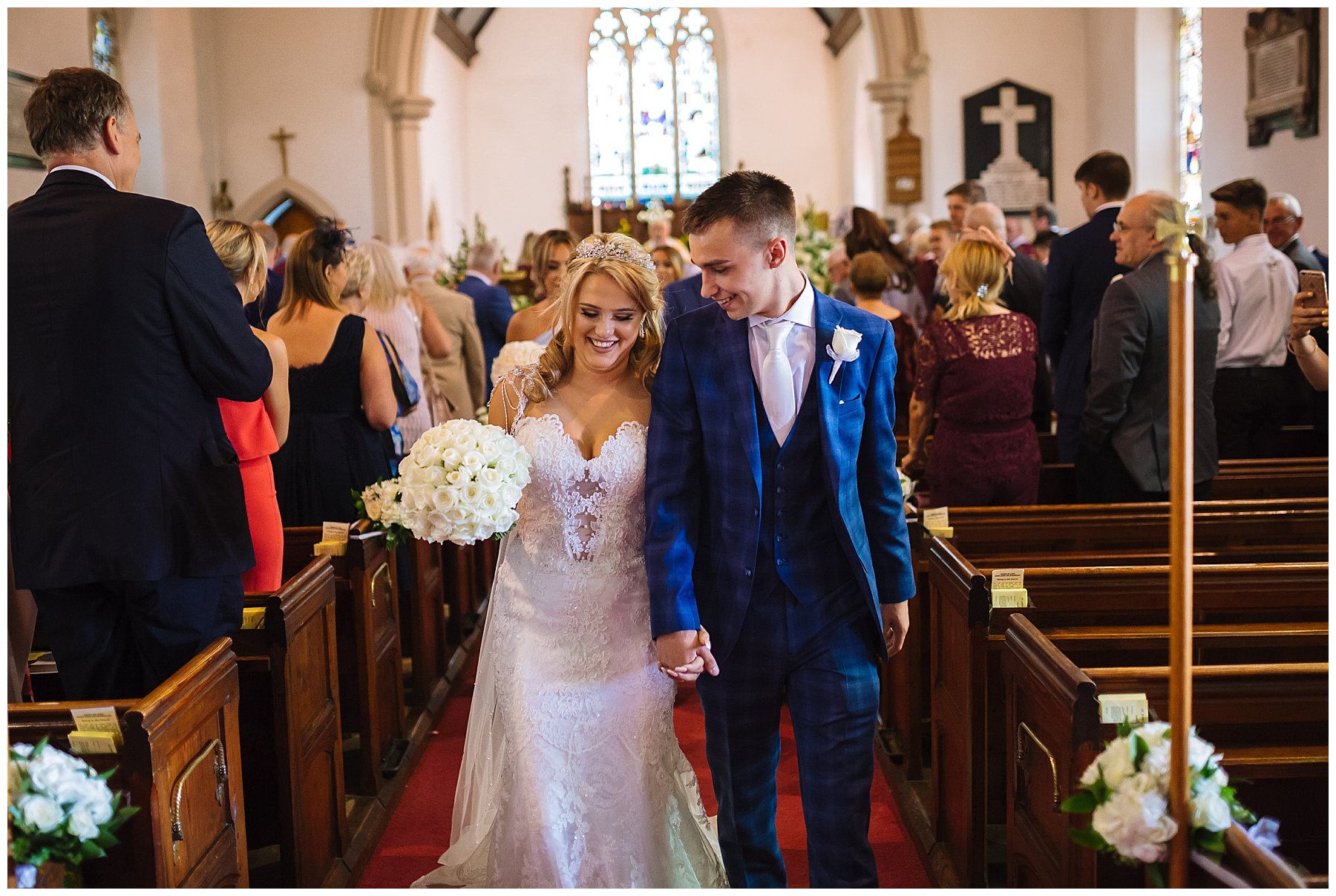 bride and groom smile as they leave church