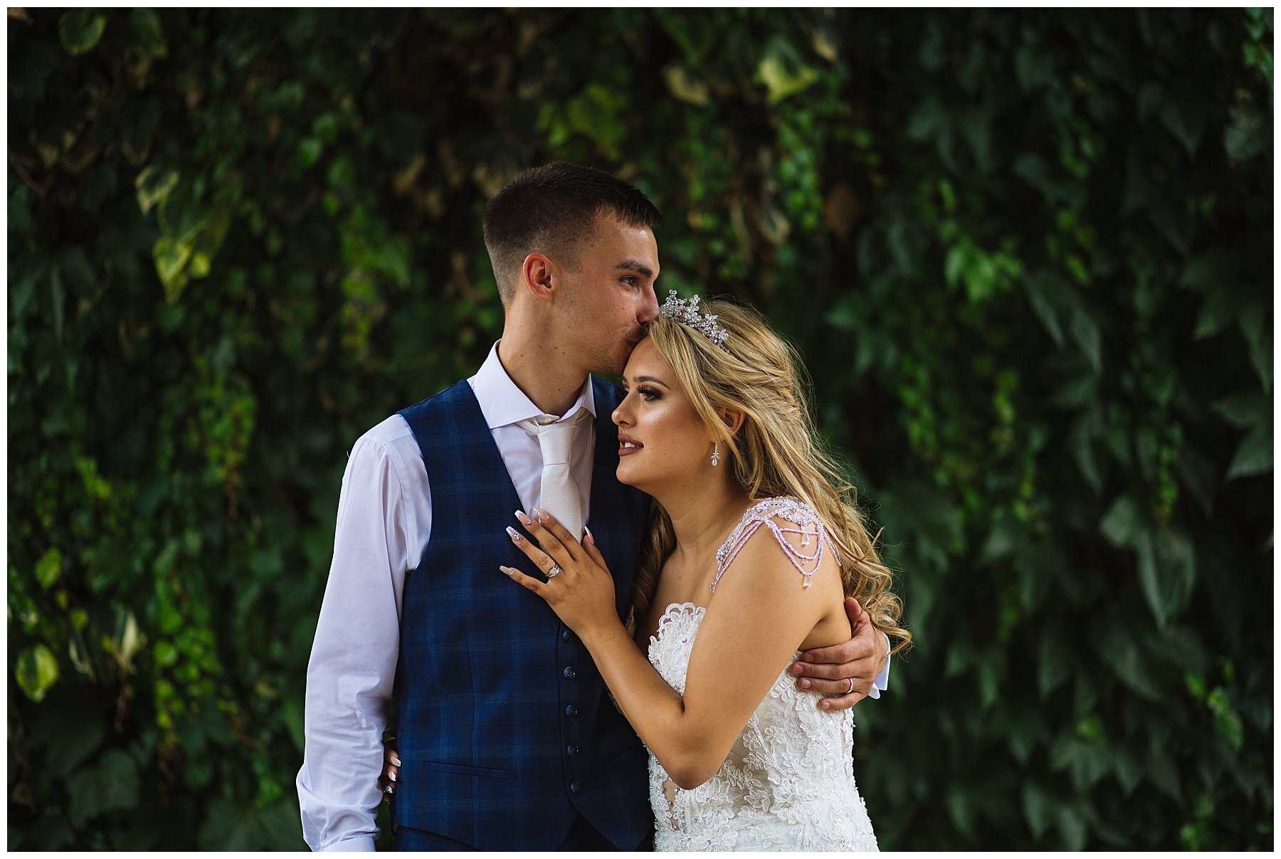 Groom kisses brides forehead during couples portraits