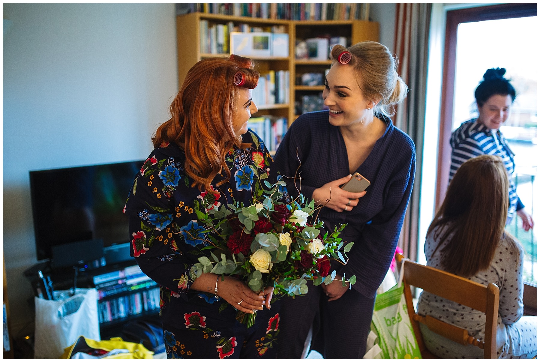 bride and bridesmaid share a look over bridal flowers