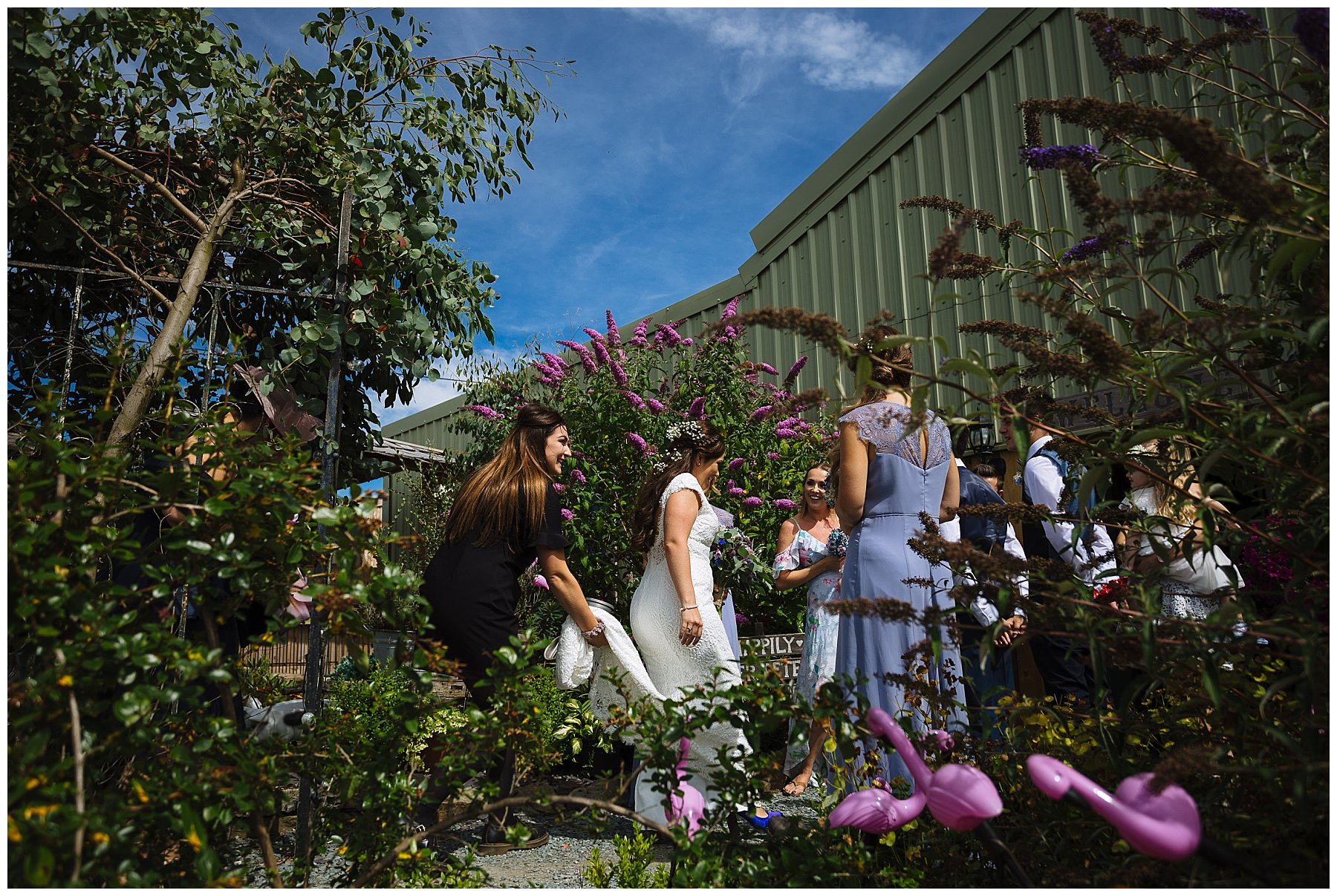 Wellbeing farm staff assist with brides dress