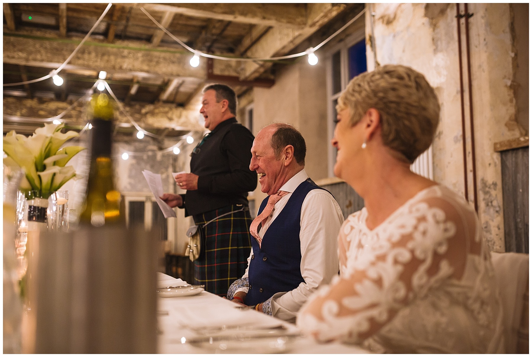 bride and groom laugh during speeches