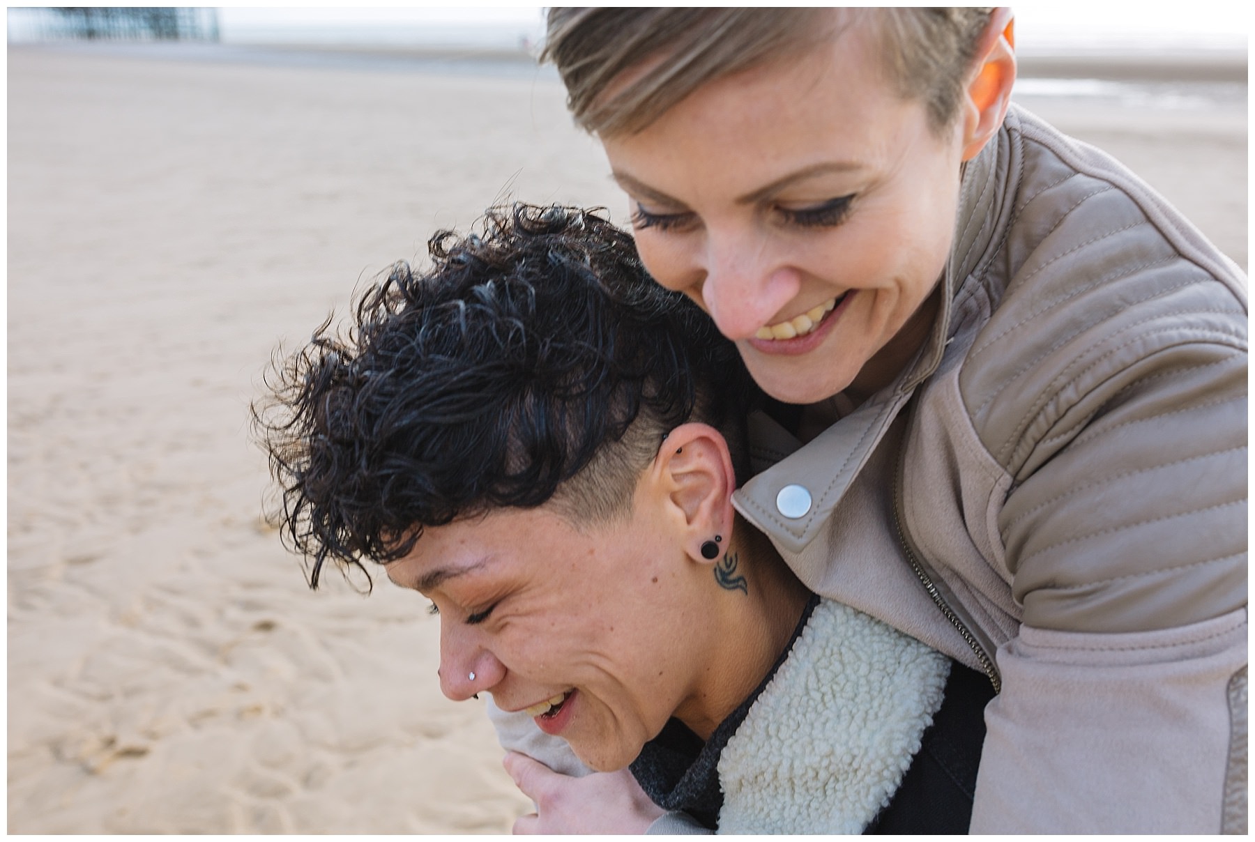 Couple piggy back along Blackpool beach
