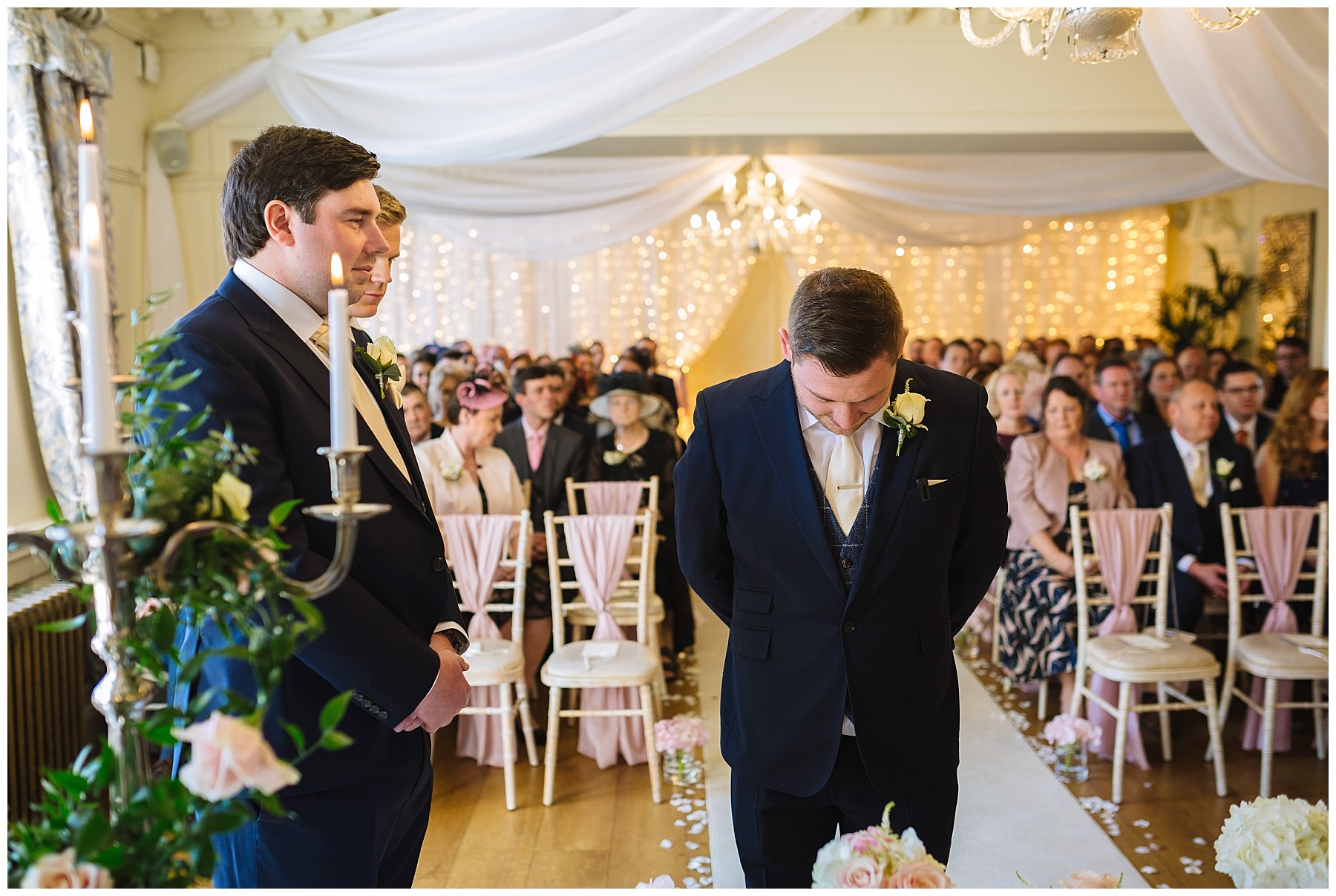 Groom nervously waits for his bride in the ceremony room at Eaves Hall