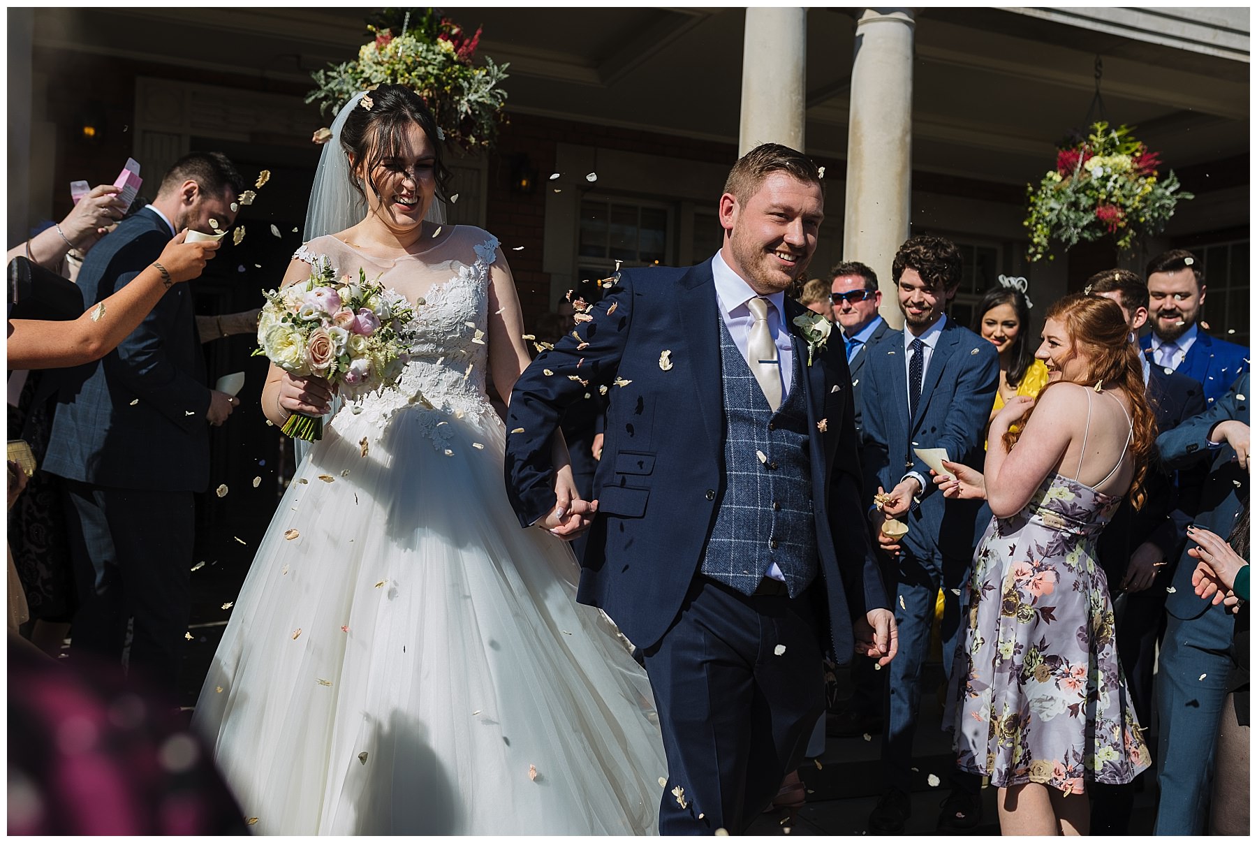 confetti thrown over bride and groom at the front of eaves hall