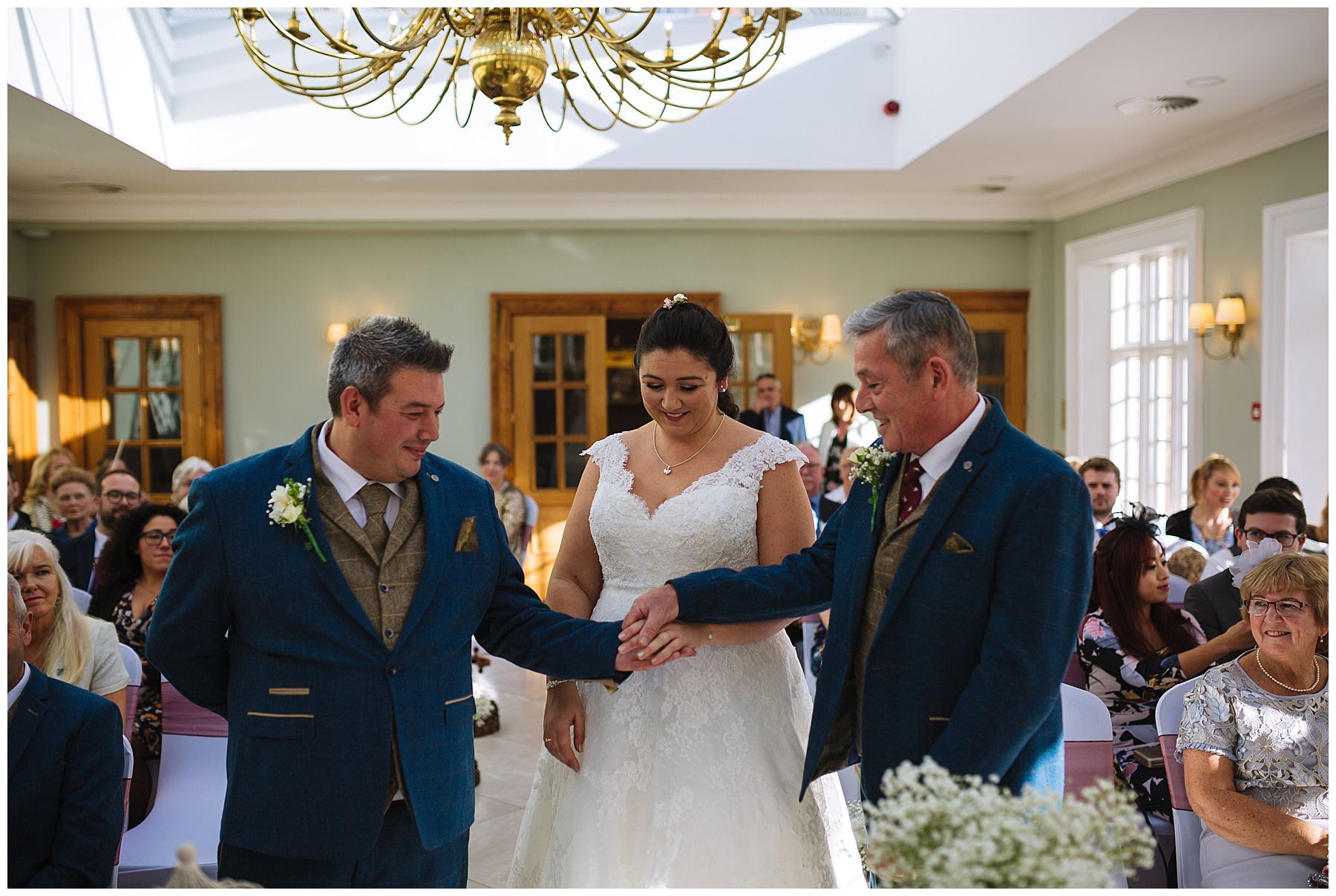 Father of the bride passes hand of his daughter to groom