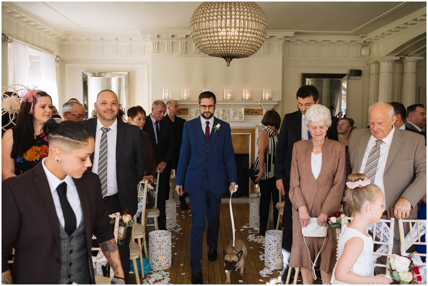 Groomsman walks the isle with French Bulldogs