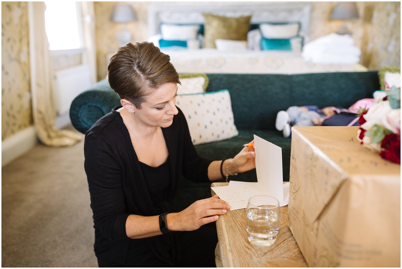 Bride writes a card in bridal suite at eaves hall