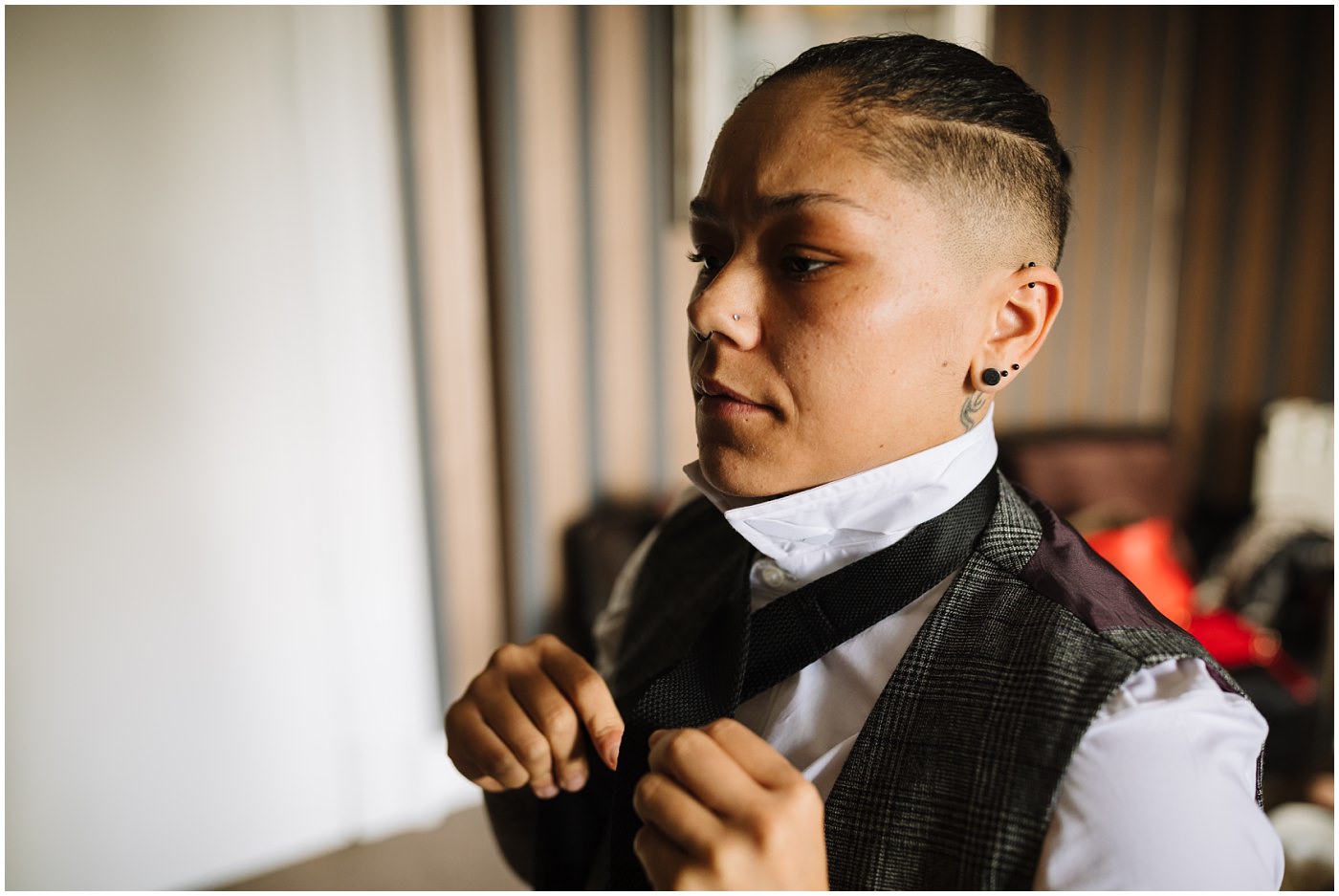 Bride fixes and adjusts tie during prep
