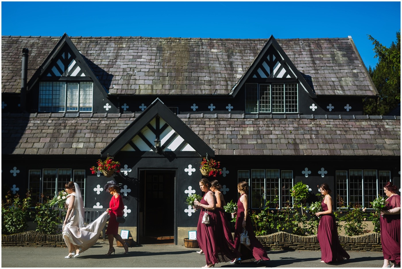 bride and bridesmaids walk to ceremony at samlesbury hall