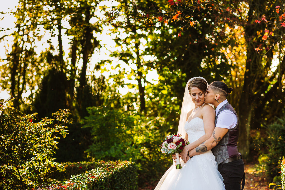 Two brides in the gardens at Eaves Hall on their wedding day