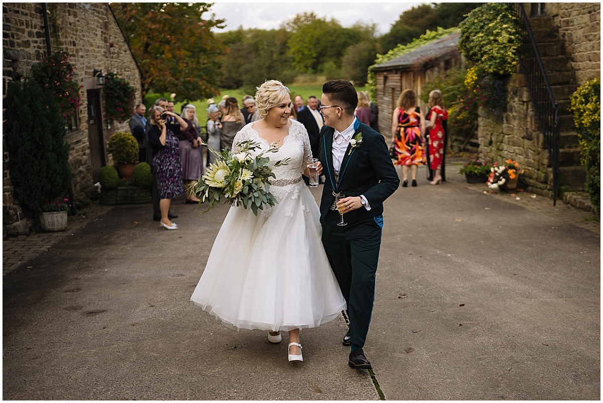 Two brides walk through hyde bank farm on their wedding day