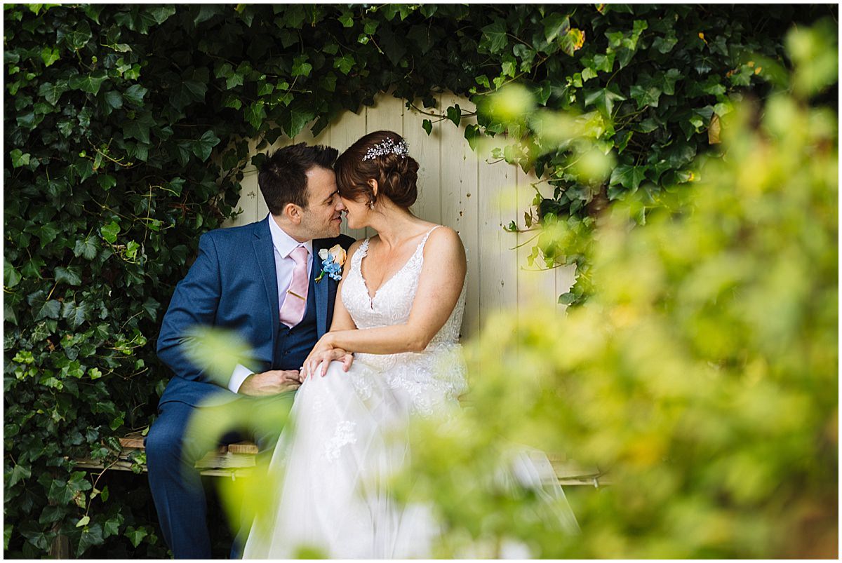Bride and Groom share a kiss in the gardens at styal lodge