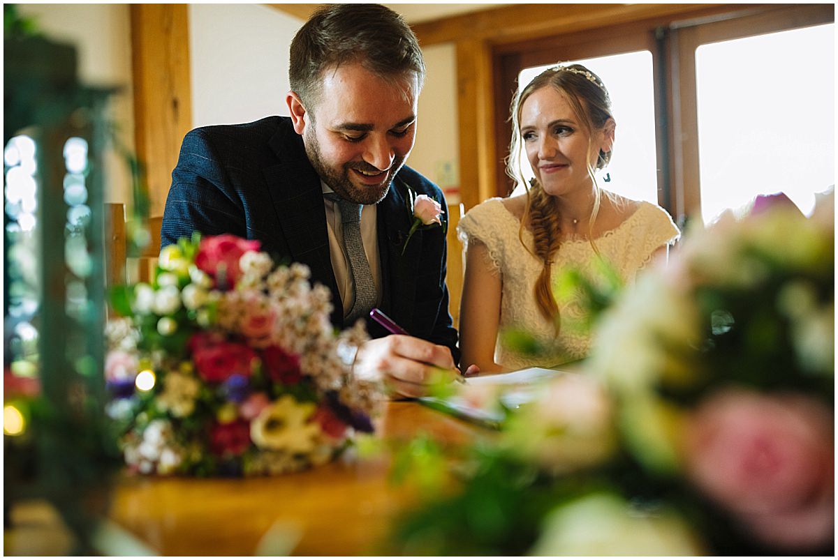 bride and groom sign the register at sandhole oak barn