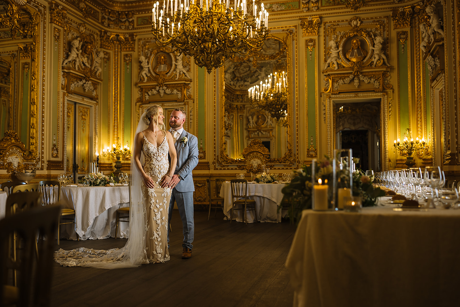 A couple shares a romantic moment in a beautifully decorated Palazzo Parisio in Malta featuring ornate details and candlelit tables.