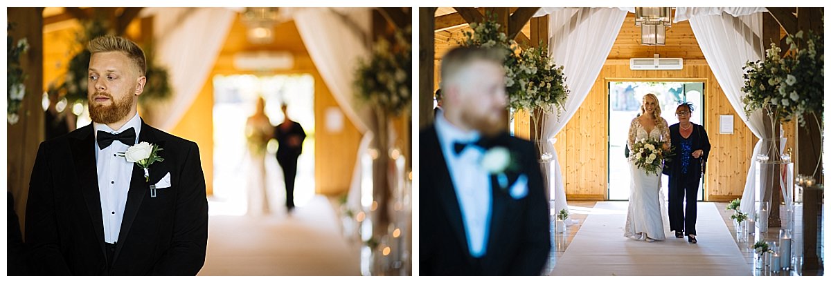 A groom stands at the altar nervously awaiting his bride, who is being escorted down the aisle by her mother in a beautifully decorated venue.