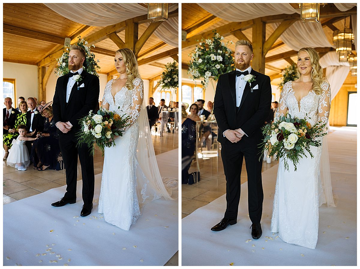 A bride and groom standing together during their wedding ceremony, surrounded by floral decorations and an audience.