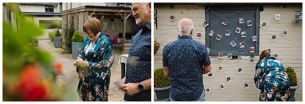 A joyful gathering with two individuals admiring photos displayed on a wall, surrounded by a charming outdoor setting.