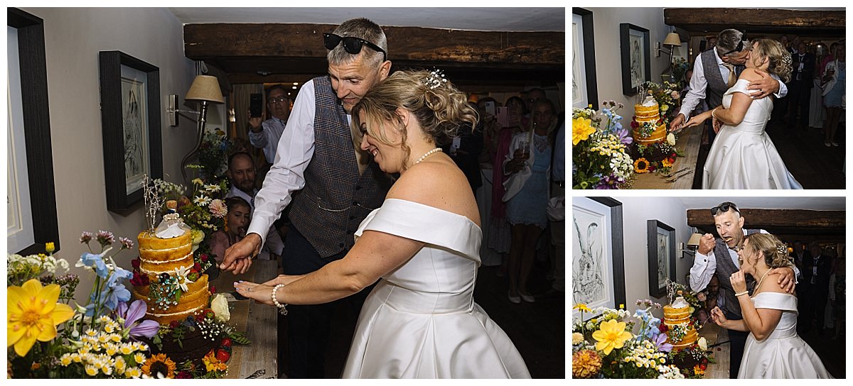 A couple joyfully cutting their wedding cake, surrounded by flowers and guests, capturing a special moment during the celebration.