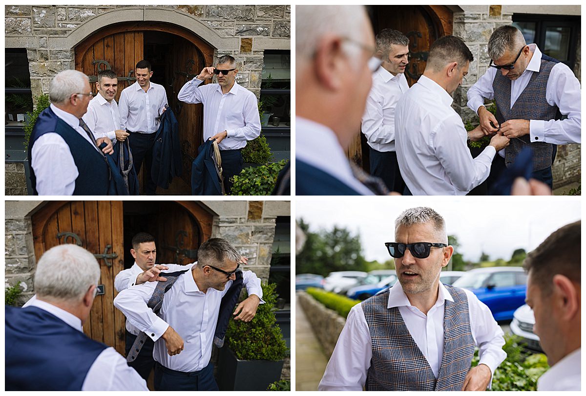 A group of four men in formal attire adjust their outfits and accessories outside a building, with a focus on camaraderie and preparation for a wedding.