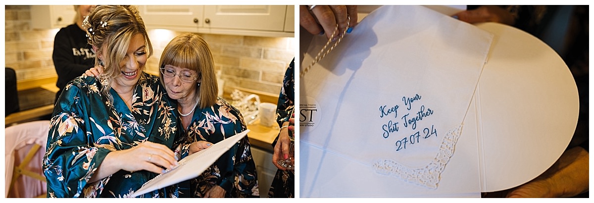 A bride and her grandmother joyfully look at a photo album, with a personalized handkerchief showcasing a message and date beside them.