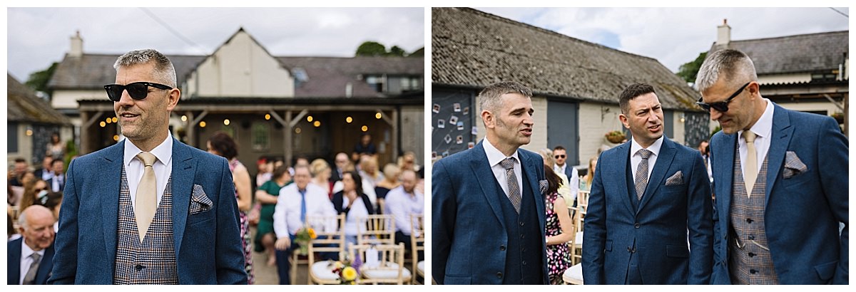 Three men in stylish suits engaged in conversation at an outdoor gathering, with guests seated in the background.