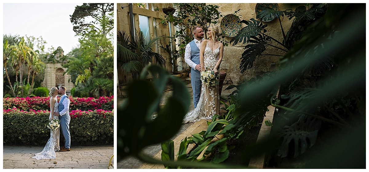 A couple embraces in a lush garden setting, showcasing the bride's intricate lace gown and a bouquet, surrounded by vibrant greenery and flowers at the stunning Palazzo Parisio, Malta