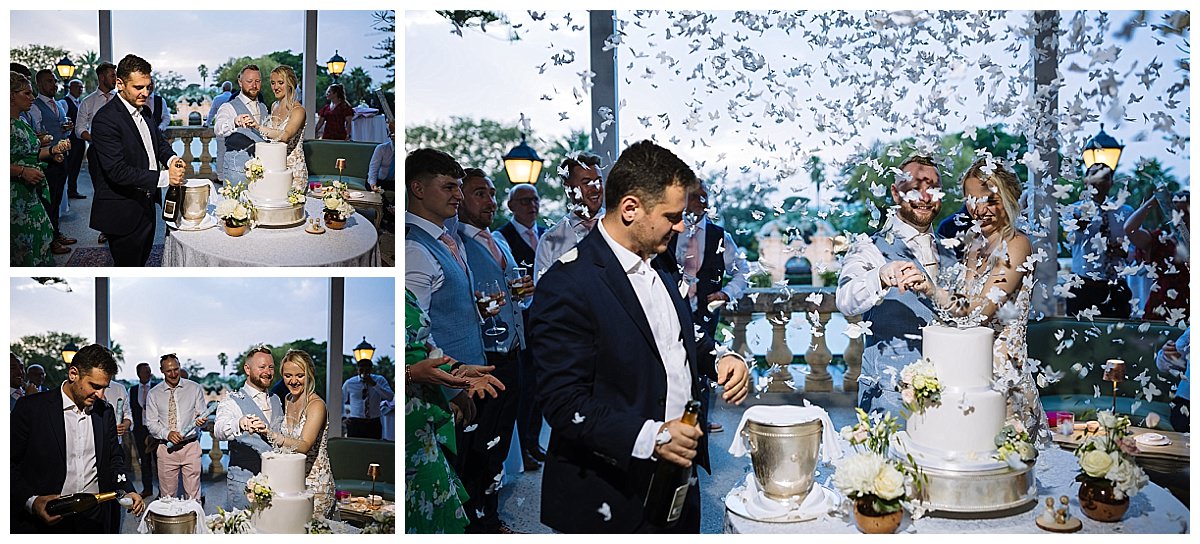 A joyous wedding scene featuring a couple cutting their cake amidst a flurry of white confetti, surrounded by smiling guests.